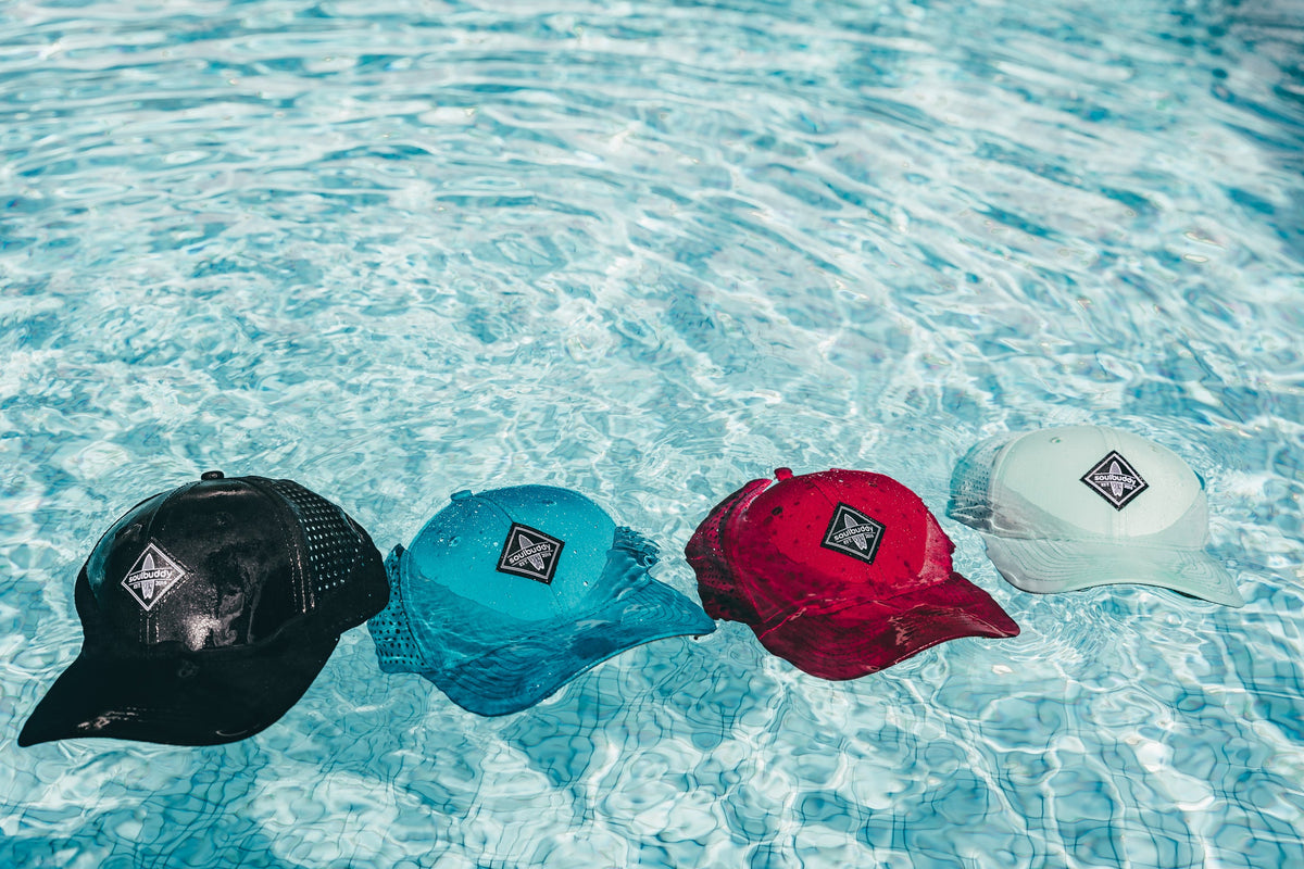 Vier Soulbuddy Performance Caps schwimmen im Pool – Cap waschen und pflegen