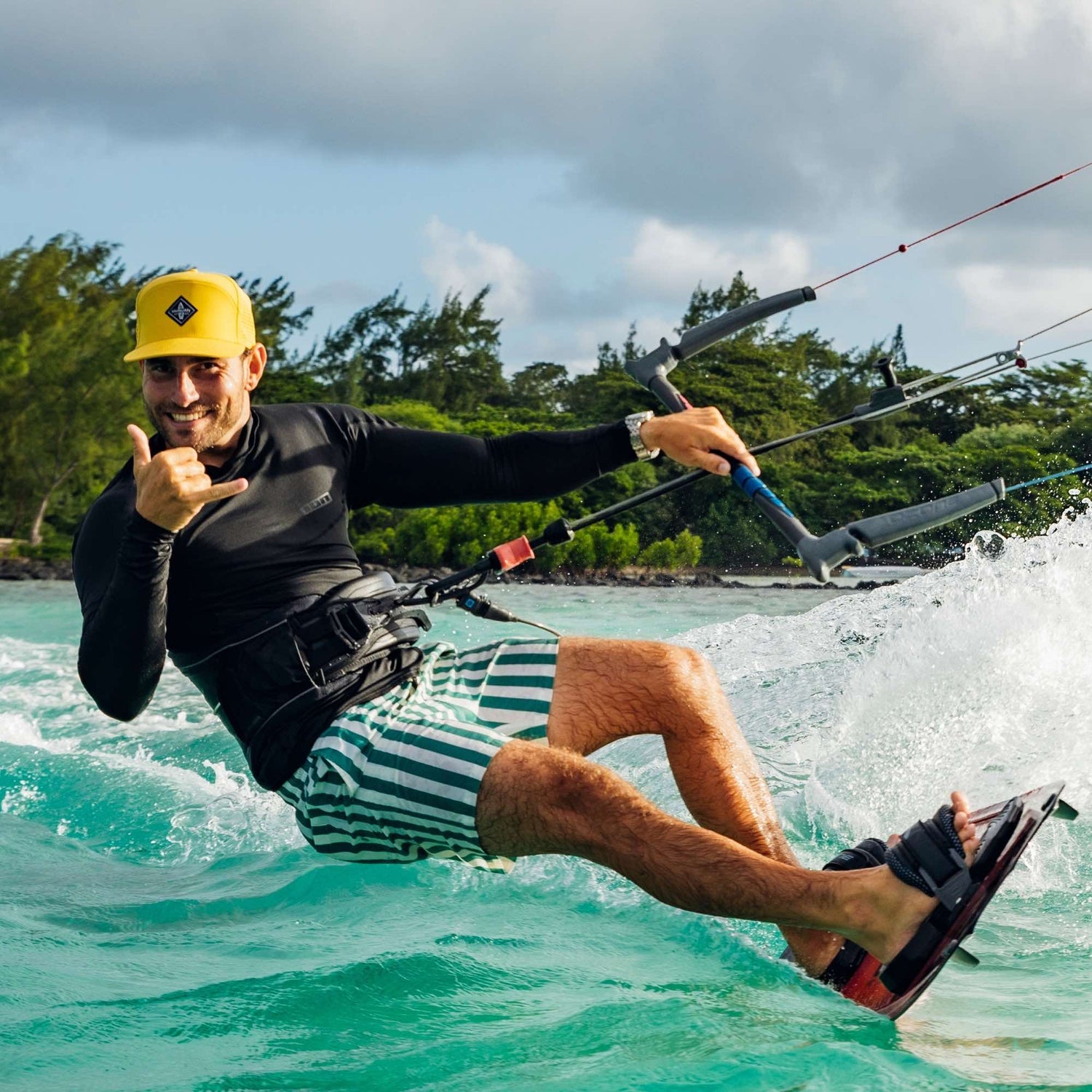 Sportlicher Mann trägt gelbe Performance Snapback Cap beim Kitesurfen auf dem Meer mit dynamischer Bewegung im Wasser