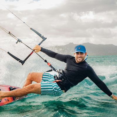 Soulbuddy Performance Cap für Damen und Herren – sportlicher Mann mit blauer Cap beim Kitesurfen auf dem Meer
